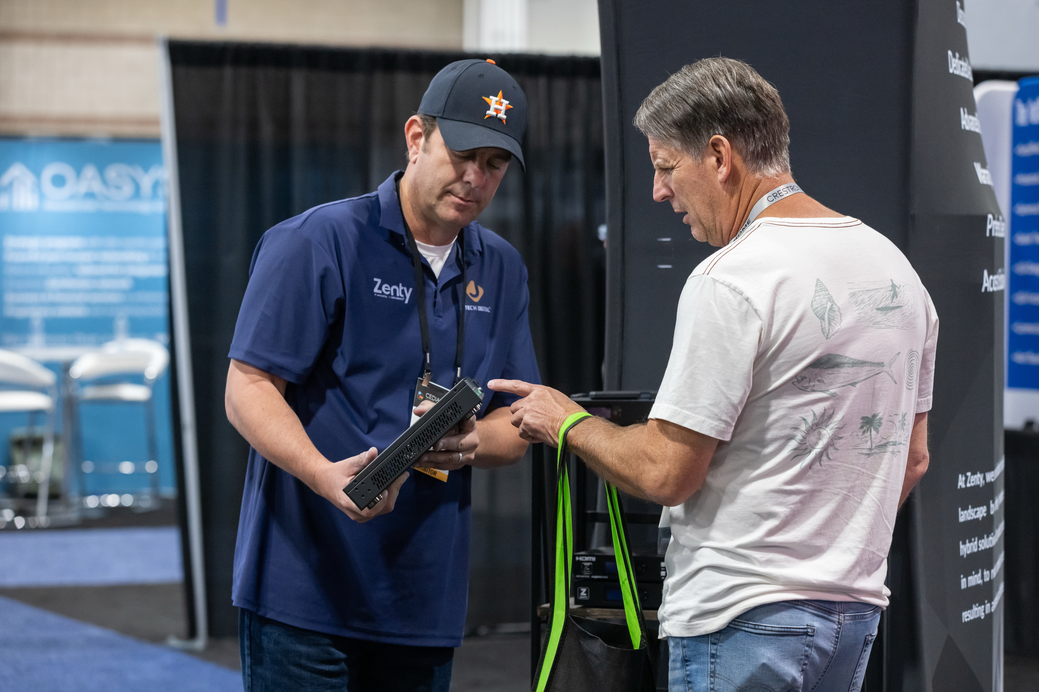 Attendee and exhibitor demonstrating a new product at CEDIA Expo/CIX