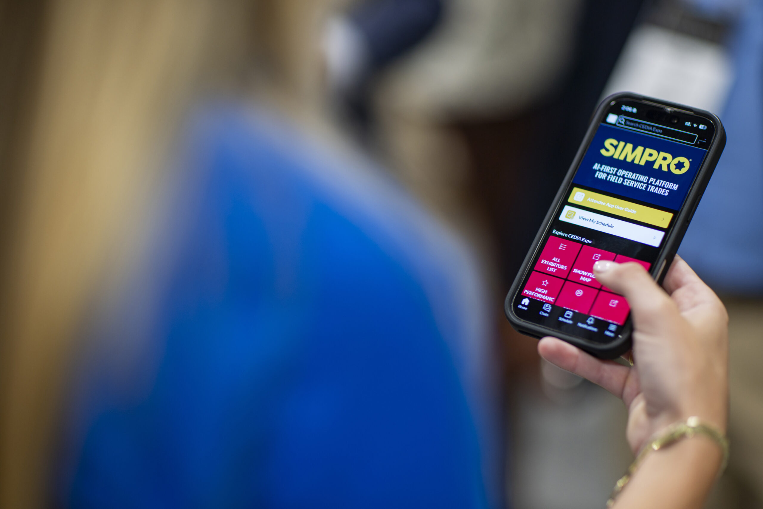 Attendee at CEDIA Expo 2026 interacting with the official show mobile app.